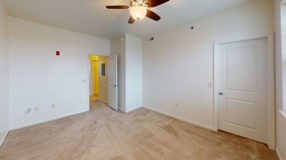 an empty living room with a ceiling fan and a door to a yellow room  at Hunters Pond Apartment Homes, Champaign, 61820