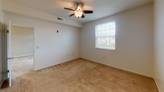 an empty living room with a ceiling fan and a window  at Hunters Pond Apartment Homes, Champaign