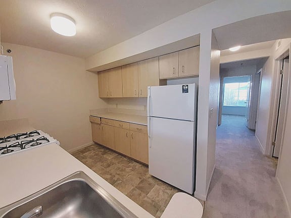 a kitchen with a white refrigerator and a sink  at Hunters Pond Apartment Homes, Champaign, Illinois