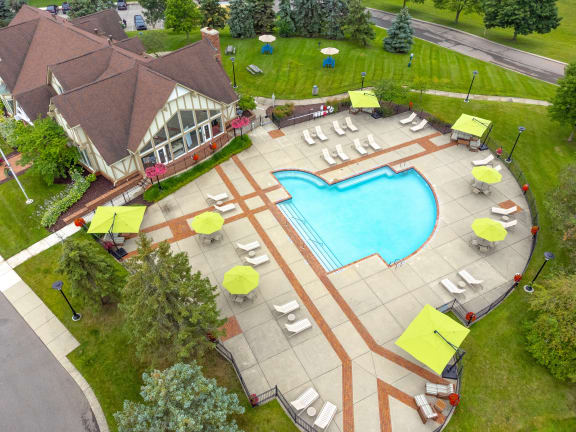 an aerial view of a resort style pool with lounge chairs and umbrellas at Stone Ridge Apartments, Michigan
