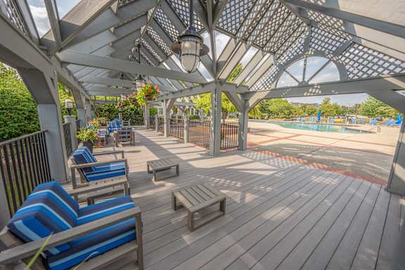 A wooden deck with blue and white striped chairs and a table.