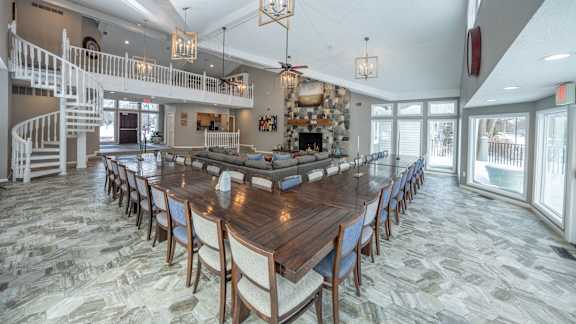 A large dining room with a long table and chairs.