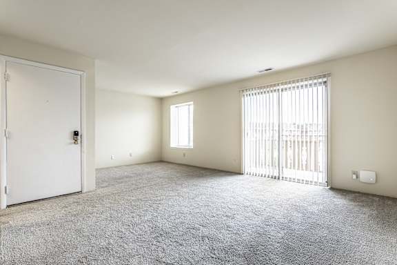 A room with a white door and a window with blinds.