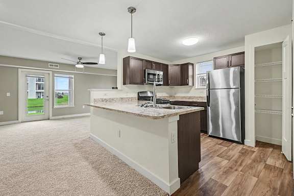 A kitchen with a pantry and stainless steel appliances at The Reserve at The Reserve at Destination Pointe in Grimes, IA 50111