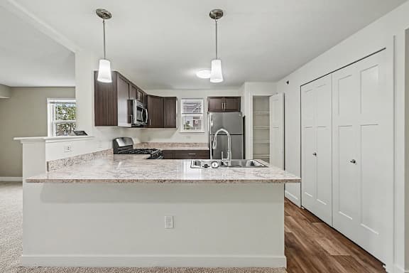 A kitchen with a breakfast bar and a window at The Reserve at The Reserve at Destination Pointe in Grimes, IA 50111