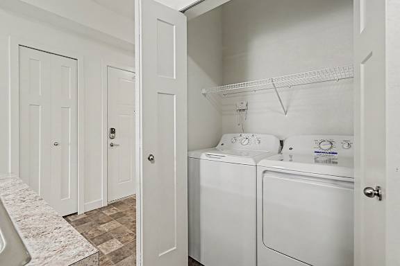 A laundry area with a washer and dryer at The Reserve at The Reserve at Destination Pointe in Grimes, IA 50111