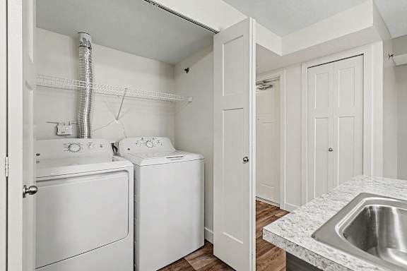 A white laundry area with a washer and dryer at The Reserve at The Reserve at Destination Pointe in Grimes, IA 50111