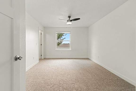 A large bedroom with a carpet floor and a ceiling fan at The Reserve at The Reserve at Destination Pointe in Grimes, IA 50111