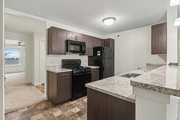 A kitchen with a breakfast bar at The Reserve at The Reserve at Destination Pointe in Grimes, IA 50111