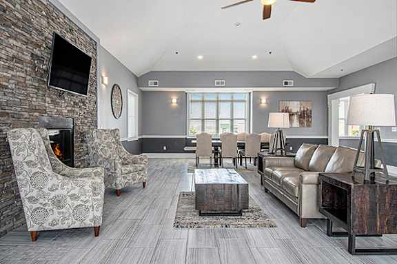 A community building with a fireplace and a television on the wall at The Reserve at Destination Pointe apartments, Grimes, IA 50111