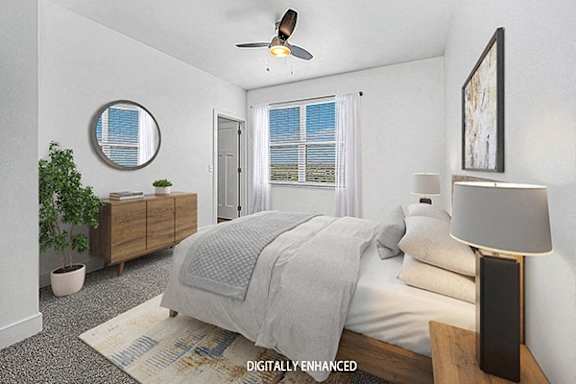 A bedroom with a bed, a ceiling fan, and a potted plant at The Reserve at Destination Pointe apartments, Grimes, IA