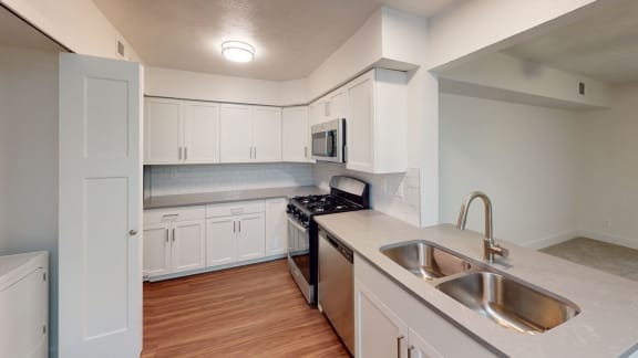 an empty kitchen with white cabinets and a sink at Green Ridge Apartments, Michigan, 49544