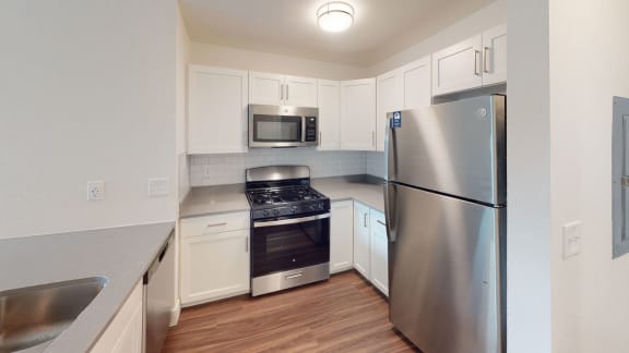 a kitchen with stainless steel appliances and white cabinets at Green Ridge Apartments, Grand Rapids, MI, 49544