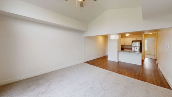an empty living room with a kitchen in the background at Green Ridge Apartments, Grand Rapids, Michigan
