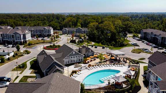 An aerial view of a residential area with houses and a swimming pool. at River Crossing Apartments, St. Charles