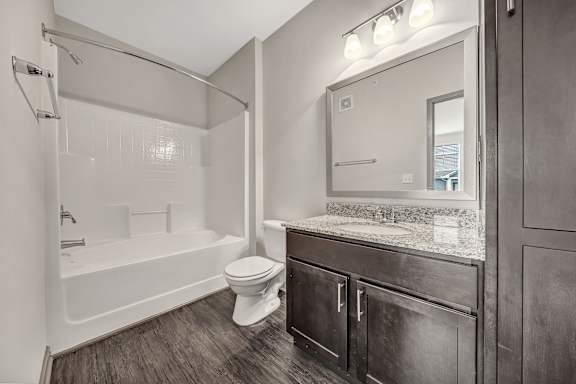 A bathroom with a white tub, toilet, and sink. at River Crossing Apartments, Missouri, 63303