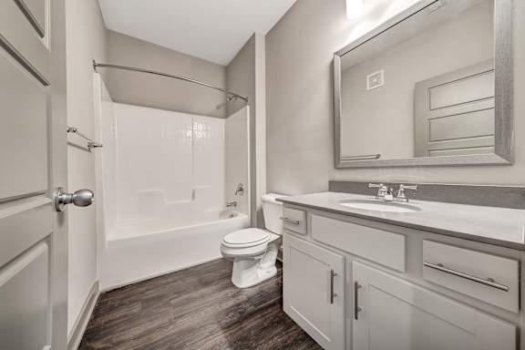 A bathroom with a toilet, sink, and shower. at River Crossing Apartments, Missouri