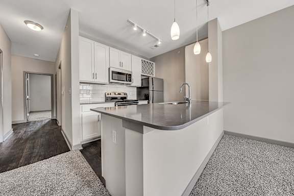 A modern kitchen with a white countertop and cabinets. at River Crossing Apartments, St. Charles, 63303