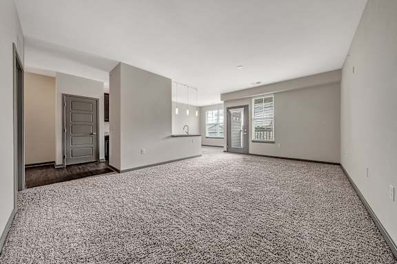 A spacious empty room with carpeted floor and white walls. at River Crossing Apartments, St. Charles