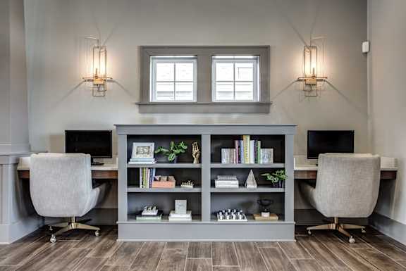 A modern home office with a desk, chair, and bookshelf. at River Crossing Apartments, St. Charles, MO