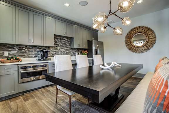 A modern kitchen with a black table and white chairs. at River Crossing Apartments, St. Charles
