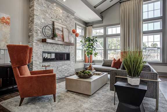 A living room with a fireplace and a chair. at River Crossing Apartments, St. Charles, Missouri