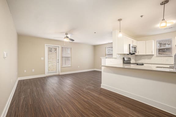 an enlarged living room and kitchen with wood floors  at Signature Pointe Apartment Homes, Alabama, 35611