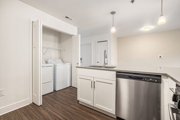 a kitchen with a full-size washer and dryer  at Signature Pointe Apartment Homes, Athens, AL, 35611