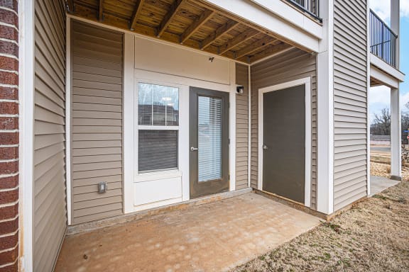 the patio of an apartment with a door to enclosed storage  at Signature Pointe Apartment Homes, Alabama, 35611