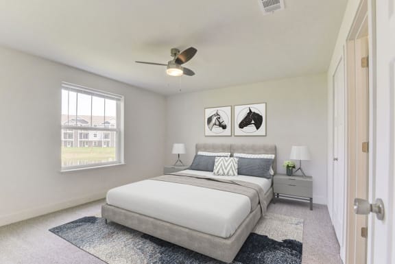 a bedroom with a bed and a ceiling fan  at Signature Pointe Apartment Homes, Athens, Alabama