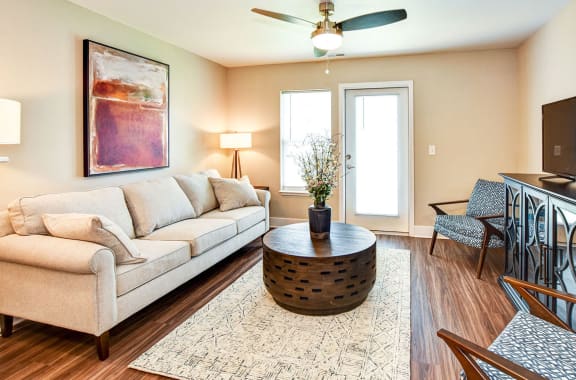 a spacious living room with a couch and a coffee table  at Signature Pointe Apartment Homes, Athens