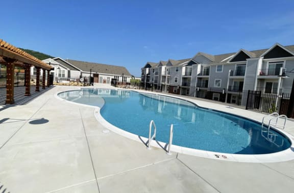 a large swimming pool with houses in the background  at Signature Pointe Apartment Homes, Alabama