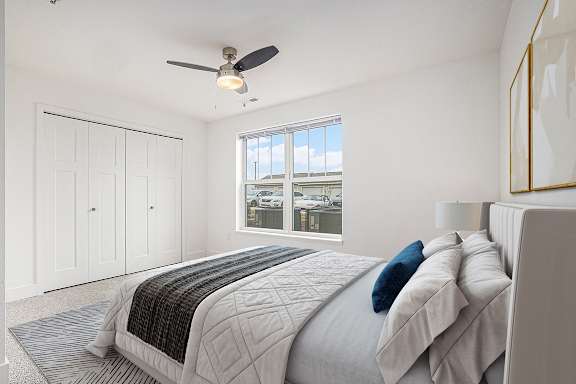 Spacious bedroom with ceiling fan and large window at Signature Pointe Apartment Homes in Athens, AL