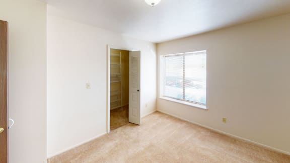 an empty living room with a large window and a closet at South Bridge Apartments, Fort Wayne, 46816
