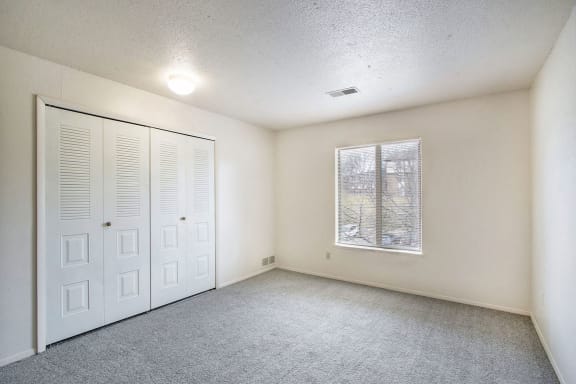 an empty living room with a window and a closet at South Bridge Apartments, Fort Wayne, IN