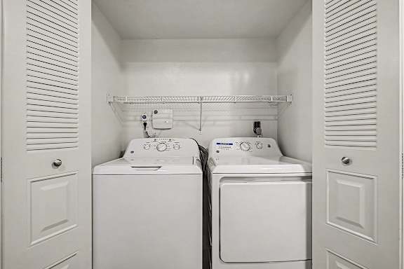A small laundry room with a washer and dryer in it.
