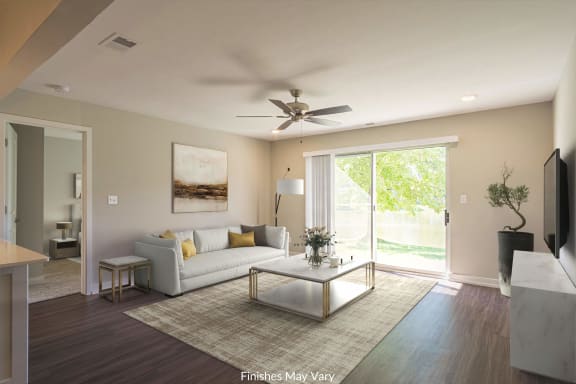a living room with a white couch and coffee table and a sliding glass door leading to a at Hillside Apartments, Wixom
