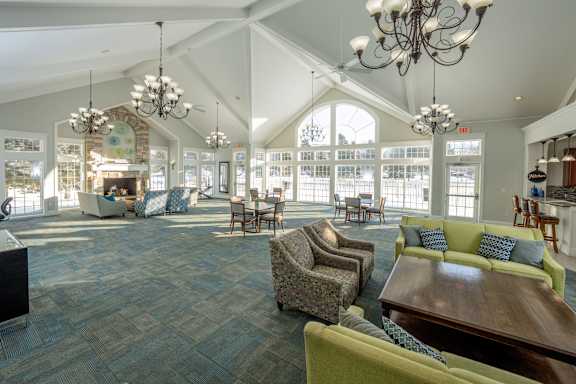 A large room with a fireplace and chairs.