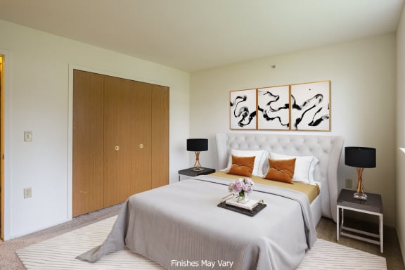 a bedroom with a large bed and two nightstands at The Springs Apartment Homes, Novi, 48377
