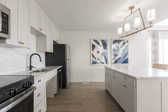 A kitchen with white cabinets and a black stove top oven.