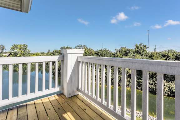 A white railing overlooks a body of water.