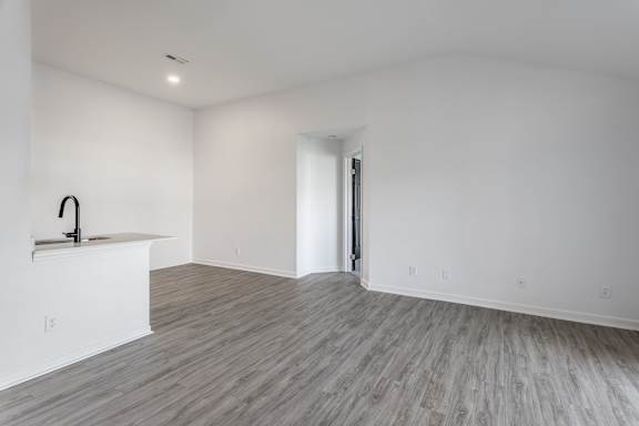 A room with a wooden floor and a sink.