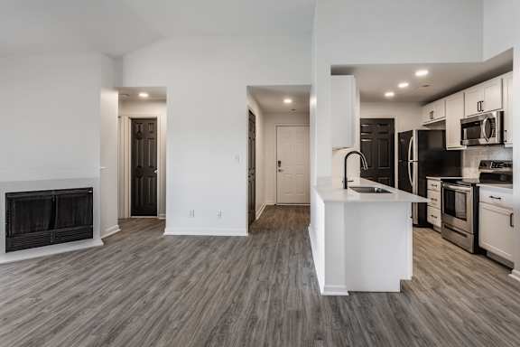 A modern kitchen with a white island and stainless steel appliances.