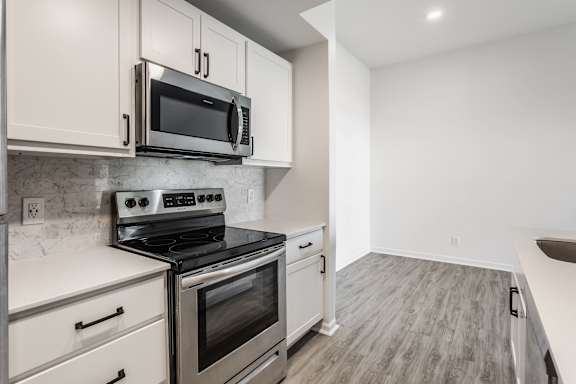 A kitchen with a stove top oven and microwave above it.