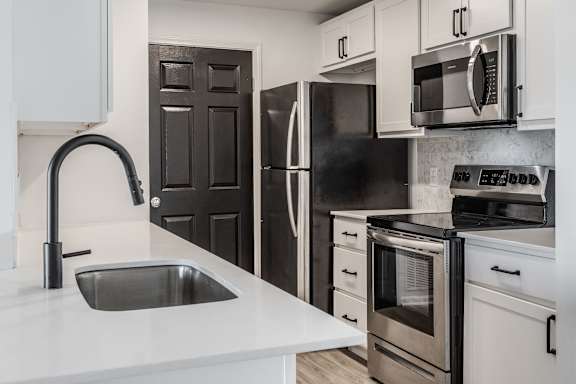 A modern kitchen with a black refrigerator and stove.
