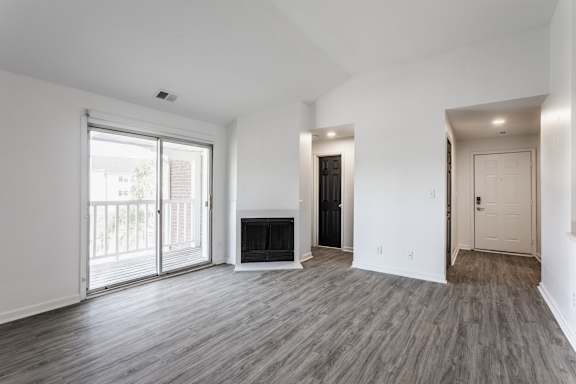 A spacious living room with a fireplace and sliding glass doors.