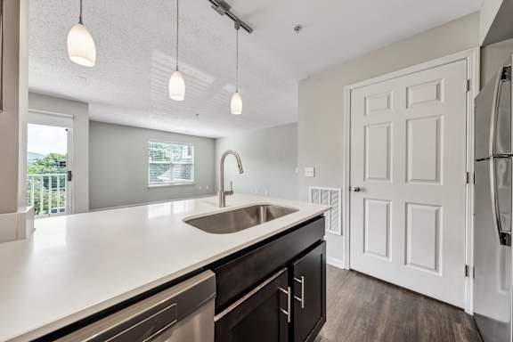 A modern kitchen with a white countertop and a stainless steel sink. at Sunscape Apartments, Roanoke, 24018