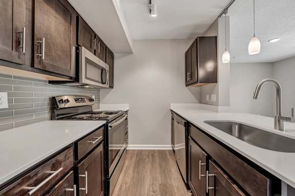 A kitchen with dark wood cabinets and a white countertop. at Sunscape Apartments, Roanoke, 24018