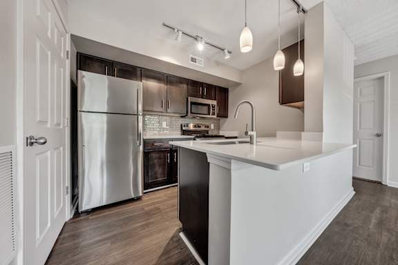 A modern kitchen with a refrigerator, microwave, and oven. at Sunscape Apartments, Roanoke