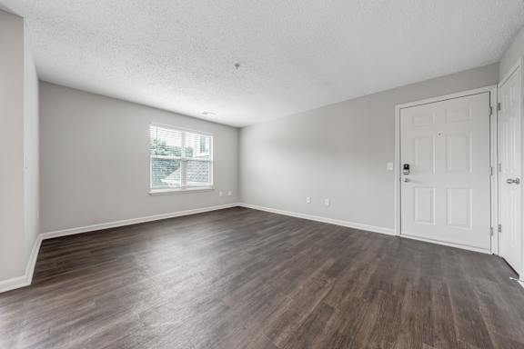 A room with wooden flooring and white walls. at Sunscape Apartments, Roanoke, Virginia